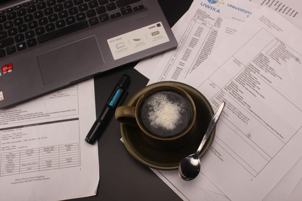 A close-up view of a desk with a coffee cup, documents, and a laptop for a productive work session.